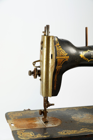 The sewing part. Detail of an old antique sewing machine, decorated with golden ornaments.の写真素材