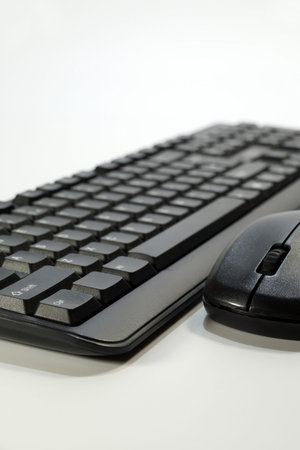 Closeup of a computer keyboard viewed from a perspective and view of a computer mouse, vertical...