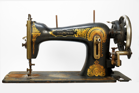 The whole silhouette of an old antique sewing machine, a machine decorated with golden ornaments. Horizontal frame.の写真素材