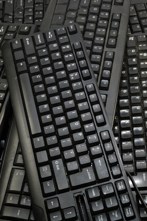 Vertical frame filled with black computer keyboards. Computer equipment used for recycling.の写真素材