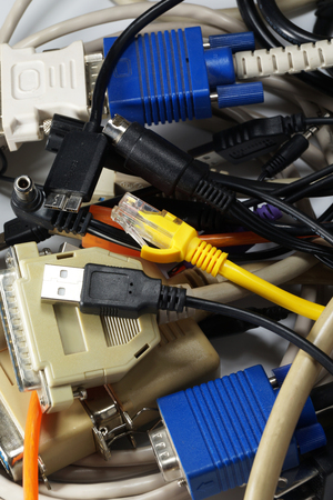 A tangle of various cables and computer plugsの写真素材