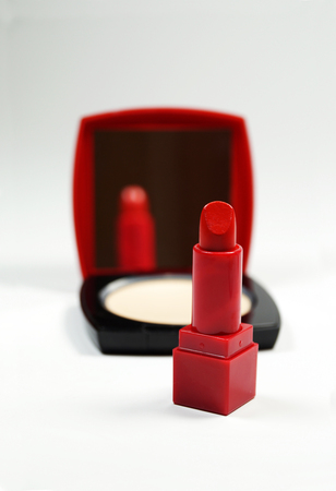 A red lipstick and a red-black powder compact with a mirrorの写真素材