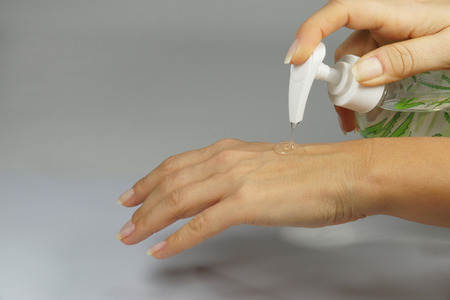 Care for female hands, applying gel on hands, horizontal cadresの写真素材