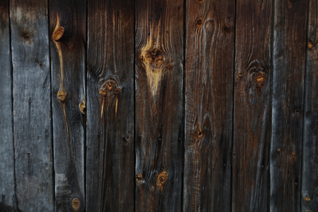 A wall of a wooden building, boards blackened with old age.の写真素材