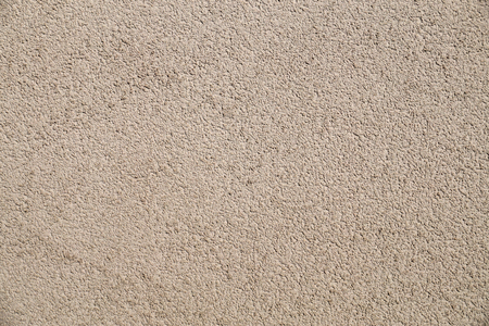 The wall is plastered with beige, coarse plaster.の写真素材
