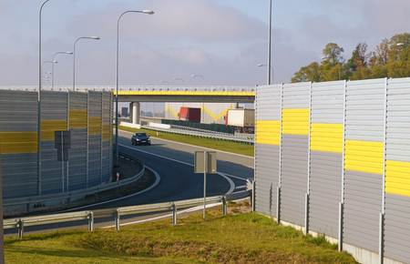 The road is protected against noise emission by noise-absorbing barrier (also called a soundwall, noise wall, noise barrier, sound barrier, or acoustical barrier) is an structure designed to protection of people against noise.の写真素材
