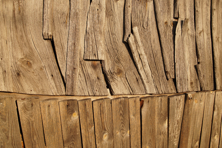 A wall of an old wooden building. Unusual planks arrangement.の写真素材