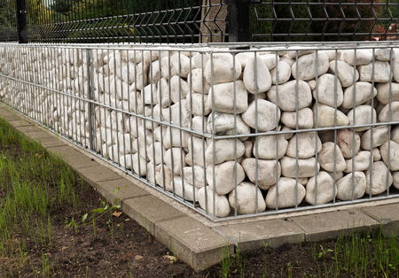 New garden fence using metal baskets filled with white pebbles. Gabion.の写真素材