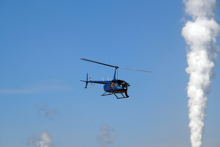 Reportage from the air. A cameraman while filming from the deck of a helicopter.の写真素材