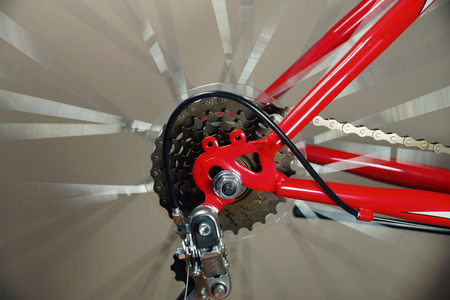 The rear wheel of the red bicycle with the derailleur, the wheel rotate.の写真素材