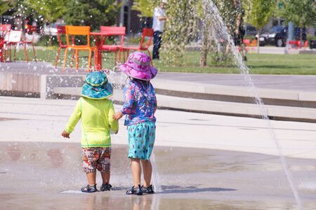 Hot summer. Children's games in the stream of water from the fountain.の写真素材