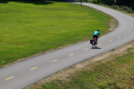 Park on the Sammamish River in Redmont. Cyclist riding on a bicycle path.の写真素材
