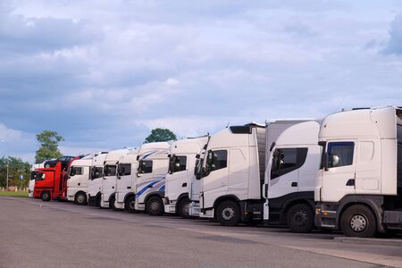 Resting place. Various types of trucks in the parking lot next to the motorway.の写真素材