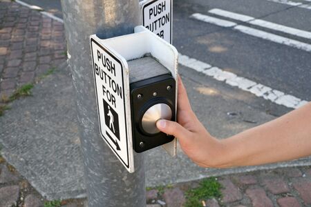 Pedestrian presses the button. A pedestrian light switch with voice guidance and comprehensive operating instructions.の写真素材