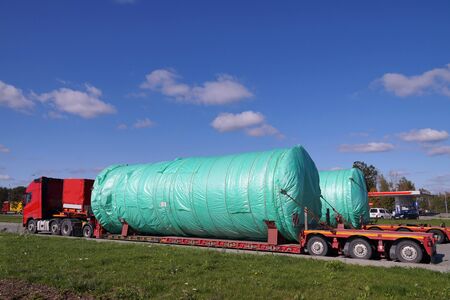 A two truck with a special semi-trailers for transporting oversized loads. Oversize Load or exceptional convoy.の写真素材