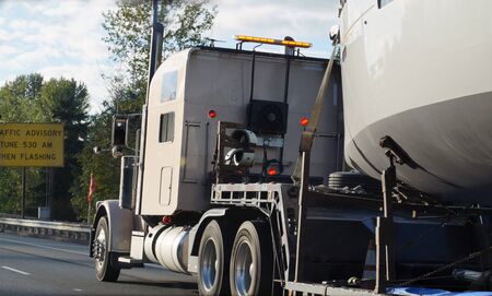 Land transport of boats and yachts. Truck with a special trailer for boat transport.の写真素材