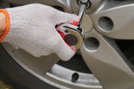 Screwing the car wheel with a torque wrench. Car repair workshop.の写真素材