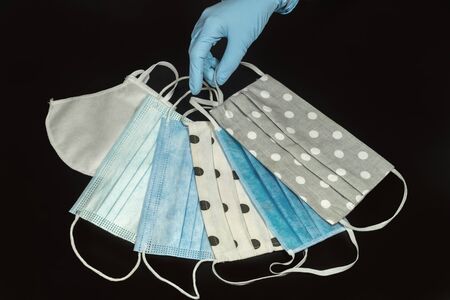 Protection against coronavirus. A gloved hand presents various types of protective masks.の写真素材