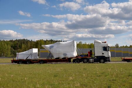 A truck with a special semi-trailer for transporting oversized loads. Oversize load or exceptional convoy. A long vehicle.の写真素材