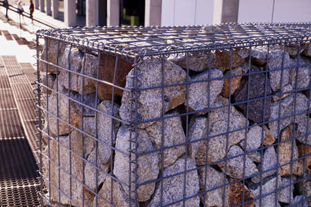 The wall next to the stairs is made of gabions (metal baskets filled with rock fragments).の写真素材
