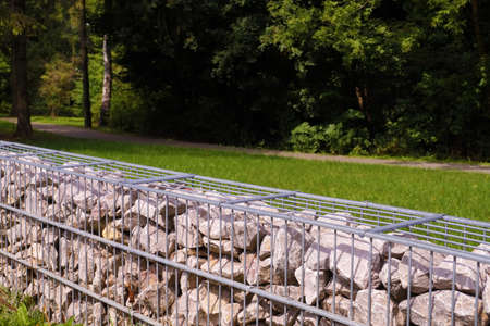 Separation of the street from the park area. A fragment of a fence made of gabions.の写真素材