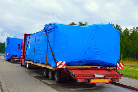 A truck with a special semi-trailer for transporting oversized loads. Oversize load or exceptional convoy.の写真素材