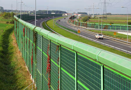 The motorway is protected on both sides with noise barriers. Barriers protect local residents from traffic noise.の写真素材