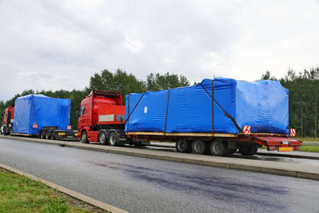 A trucks with a special semi-trailers for transporting oversized loads. Oversize load or exceptional convoy.の写真素材