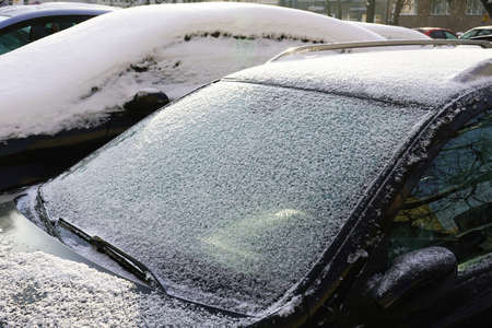 Cars covered with a thick layer of frozen snow. The estate car park in winter.の写真素材