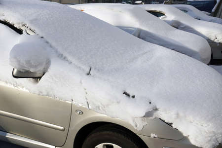 Cars covered with a thick layer of frozen snow. The estate car park in winter.の写真素材