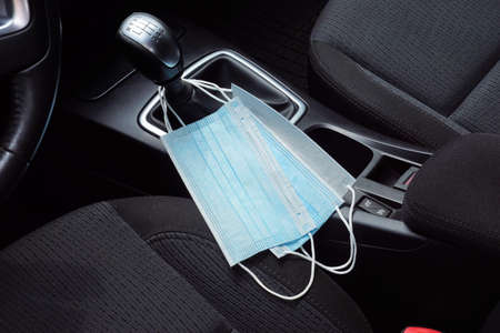 A symbolic picture of life during a pandemic. Protective hoods suspended from the gear lever in the car.の写真素材