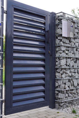 Entrance door with access control system and intercom. Gabion wall.の写真素材