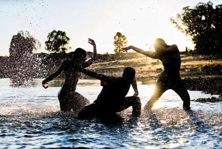 Dancers in the water of a lake at sunsetの写真素材