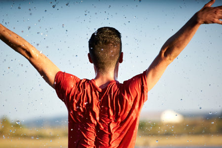 Dancer man with his back wet in a lake with a red shirt.の写真素材