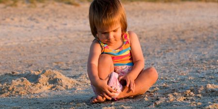 Life is worth living - a baby-girl playing on a beach down-underの写真素材
