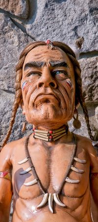 Old carved cigar store Indian - stone wall as backgroundの写真素材