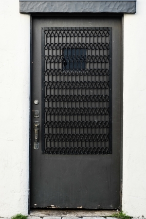 Old traditional style door on stucco wall with metal decorationの写真素材