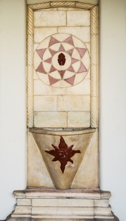 Spanish style colorful tile fountain on stucco wall の写真素材