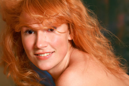 Portrait of the beautiful red-haired girl looking in an objectiveの写真素材