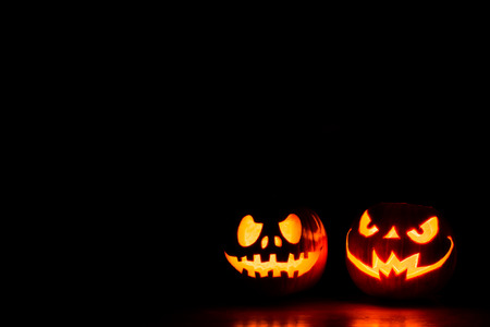 Scary Halloween pumpkins isolated on a black background with space for text. Halloween card concept.の写真素材
