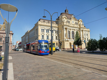 Oradea, Romania - July 12 2022: two trams and Oradea City Hall building in the background