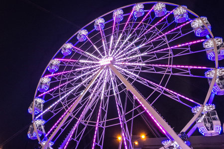 Big ferris wheel with cabin and lights during the evening. In Romaniaの写真素材