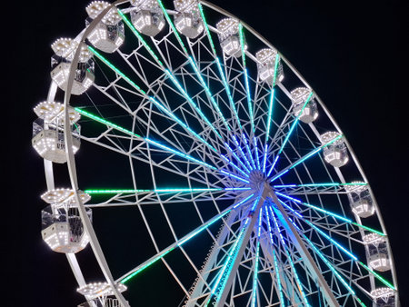 Big ferris wheel with cabin and lights during the evening