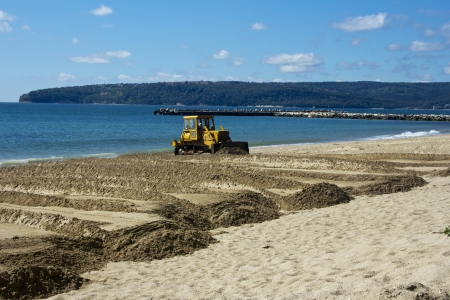 the bulldozer levels sand on a beachの写真素材