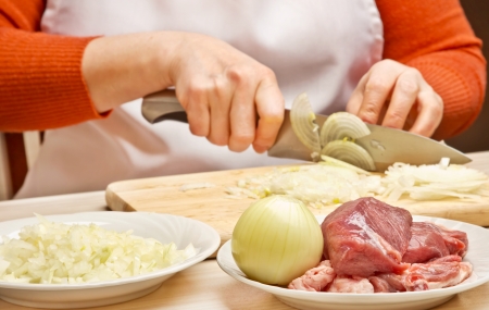 Woman cuts onionsの写真素材