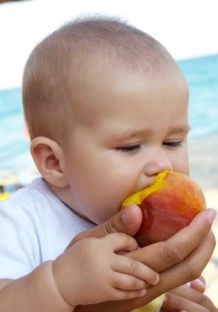 Cute baby with peachの写真素材