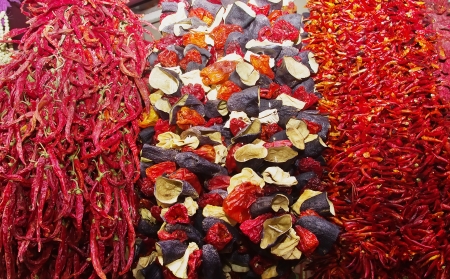 Bunches of dried vegetables hanging at an outdoor market stallの写真素材