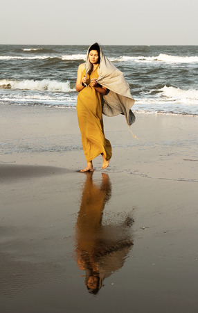 Woman walking along the beachの写真素材