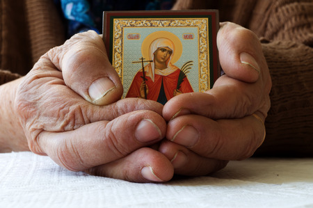 Old female hands with Orthodox iconの写真素材