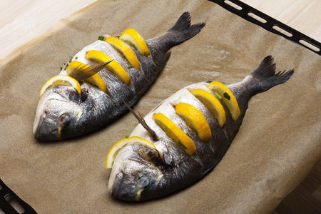 Cooked fish sea bream fish with lemon, parsley,garlic の写真素材